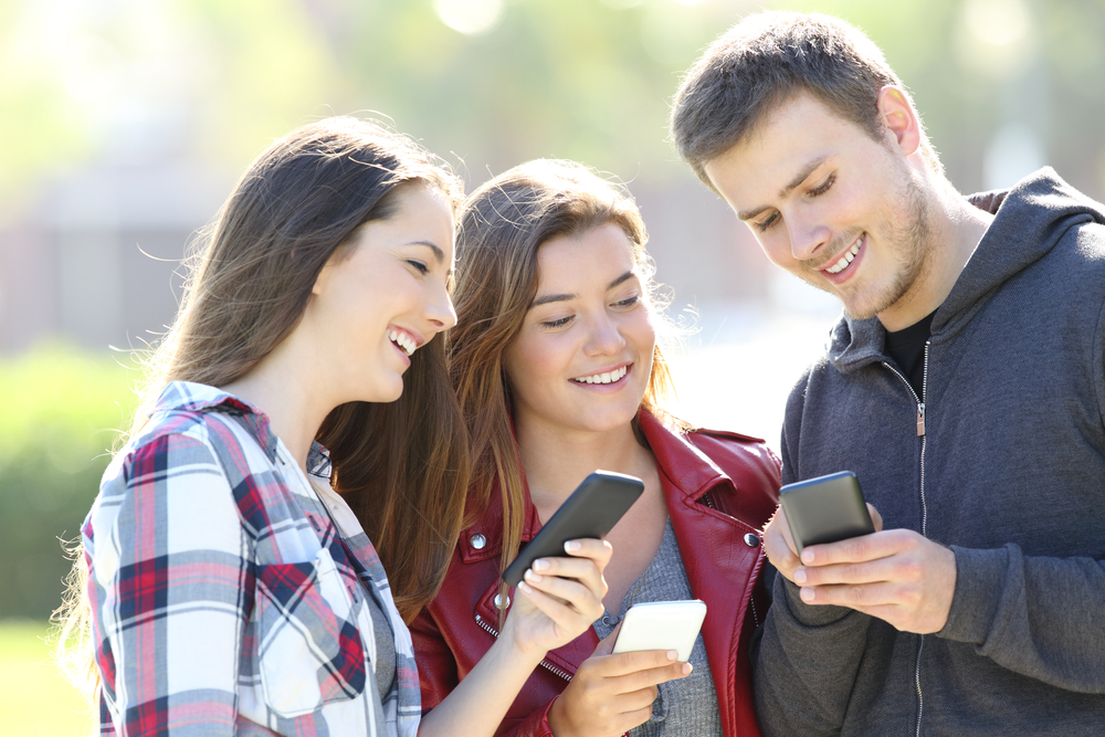 A group of friends is amazed while watching video testimonials.