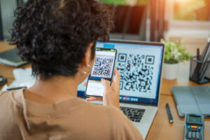 Customer scanning a QR code review sign at a small business checkout counter
